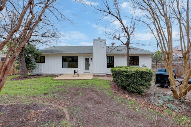 back of house featuring a lawn and a patio