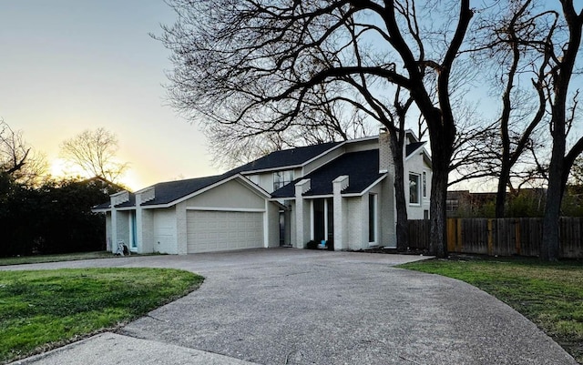 view of front of property with a garage and a lawn