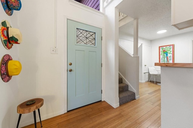 foyer featuring a textured ceiling and light hardwood / wood-style floors