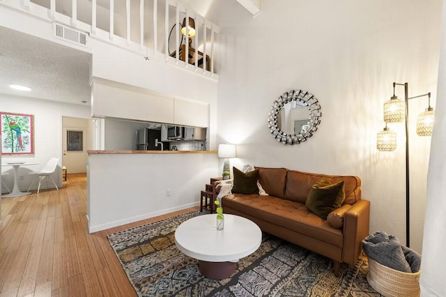 living room featuring a high ceiling and hardwood / wood-style floors