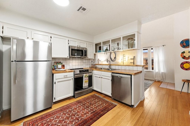 5608 Cougar Dr Unit 220, Austin, TX 78745 - kitchen with appliances with stainless steel finishes, a sink, tasteful backsplash, and white cabinetry