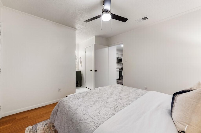 5608 Cougar Dr Unit 220, Austin, TX 78745 - bedroom with light wood-style flooring, ornamental molding, baseboards, a ceiling fan, and ensuite bathroom