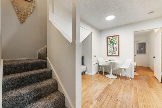 5608 Cougar Dr Unit 220, Austin, TX 78745 - stairs featuring wood finished floors, a textured ceiling, and baseboards