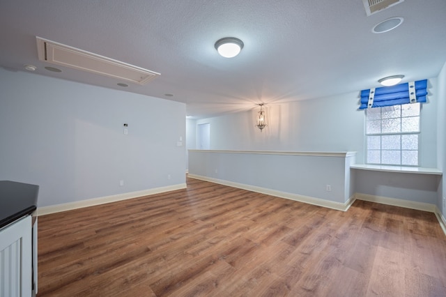 empty room with a textured ceiling and hardwood / wood-style floors