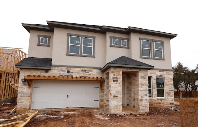 prairie-style home featuring a garage, stone siding, roof with shingles, and stucco siding