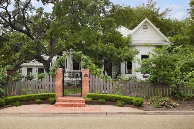 209 E Elizabeth St, Austin, TX 78704 - view of property hidden behind natural elements with a fenced front yard, a gate, and metal roof