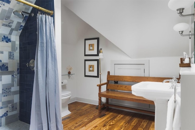 209 E Elizabeth St, Austin, TX 78704 - bathroom featuring toilet, a tile shower, wood finished floors, and lofted ceiling