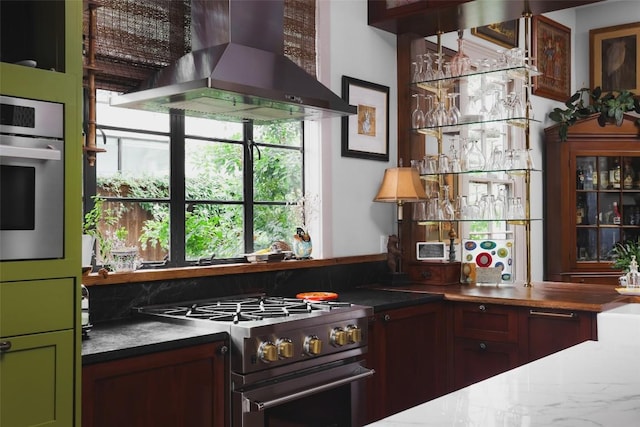 209 E Elizabeth St, Austin, TX 78704 - kitchen with wall chimney range hood, stainless steel appliances, and green cabinets