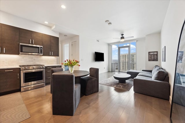 222 W Ave Unit 1312, Austin, TX 78701 - living room with a ceiling fan, light wood-type flooring, a wall of windows, and recessed lighting