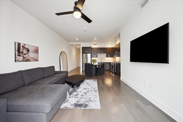 living room with wood-type flooring and ceiling fan