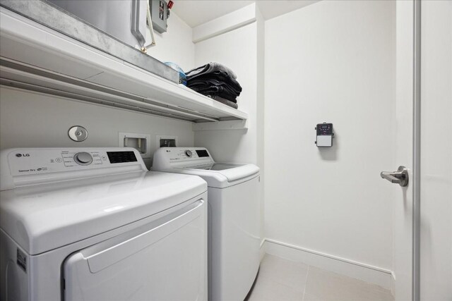 222 W Ave Unit 1312, Austin, TX 78701 - laundry room featuring washing machine and clothes dryer, light tile patterned floors, and baseboards