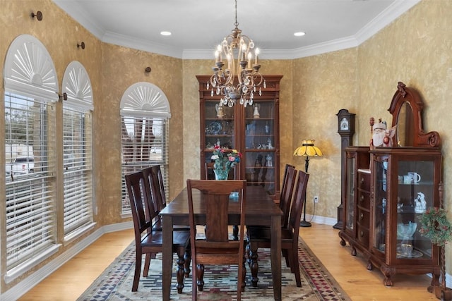 dining space featuring an inviting chandelier, ornamental molding, and light wood-type flooring