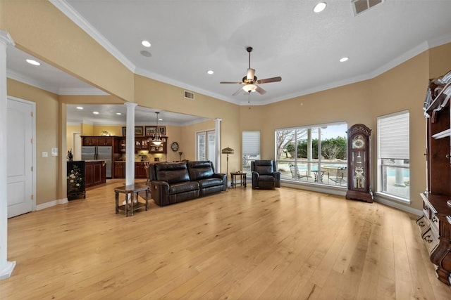 living room featuring crown molding, ceiling fan, light hardwood / wood-style flooring, and ornate columns