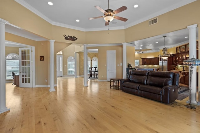 living room with crown molding, light hardwood / wood-style floors, and ornate columns