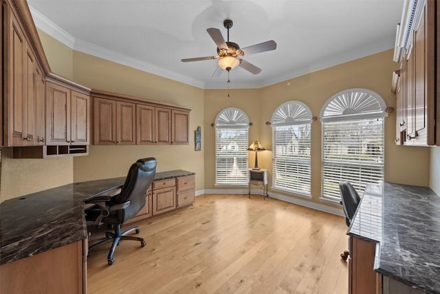 office space with built in desk, ornamental molding, plenty of natural light, and light wood-type flooring