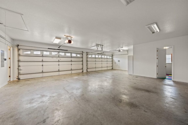 garage with a garage door opener and electric panel