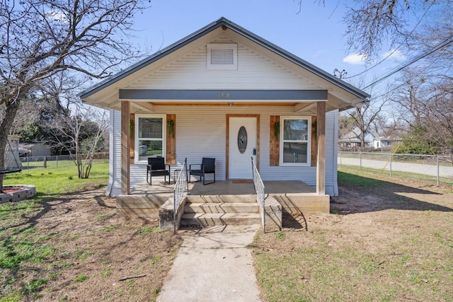 bungalow-style home featuring covered porch and a front yard