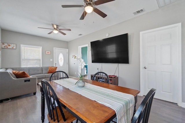 dining space featuring wood-type flooring and ceiling fan