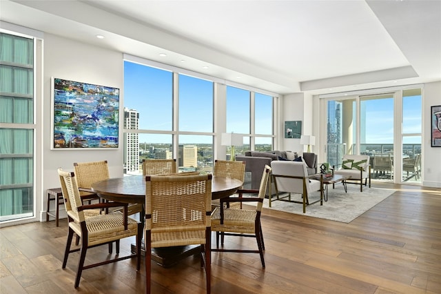 dining area featuring hardwood / wood-style flooring and a wall of windows