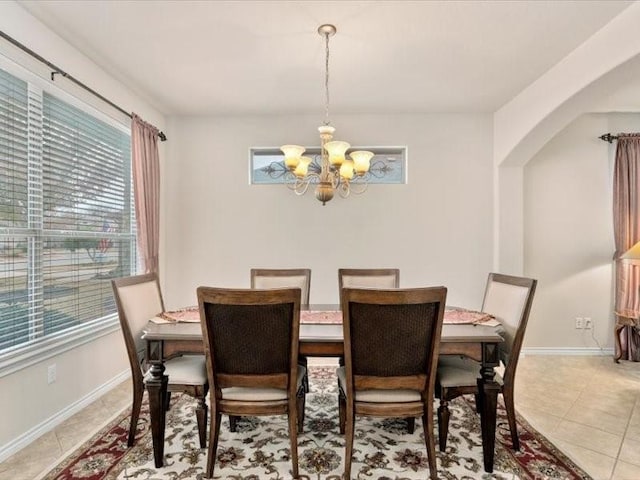 tiled dining area featuring an inviting chandelier