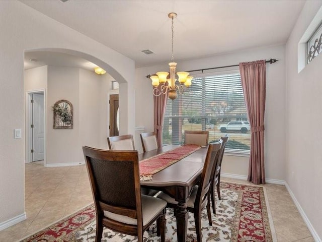 dining room with light tile patterned flooring and a notable chandelier