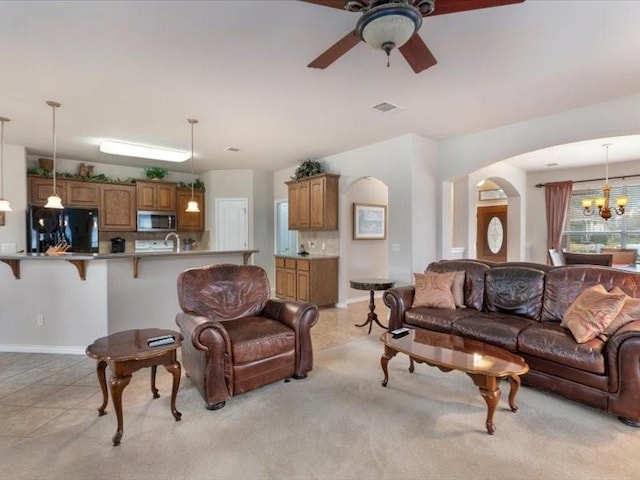 909 Big Thicket St, Georgetown, TX 78633 - living room with arched walkways, a chandelier, ceiling fan, and light tile patterned flooring