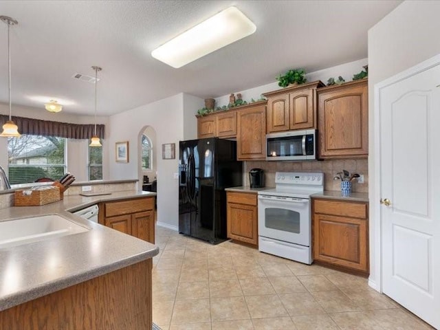 kitchen featuring sink, backsplash, hanging light fixtures, light tile patterned floors, and white appliances