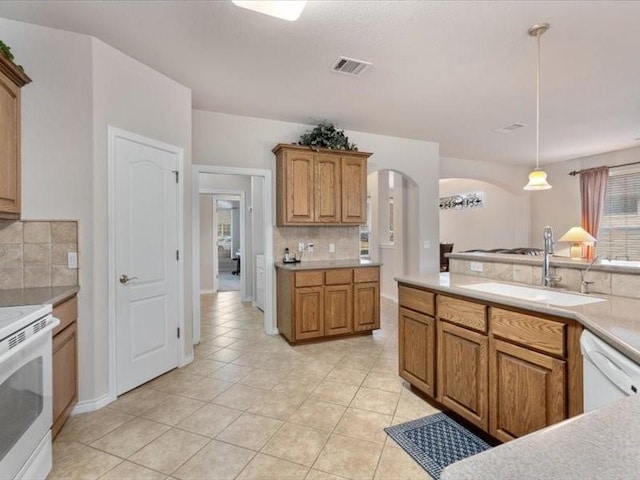 kitchen with pendant lighting, sink, decorative backsplash, light tile patterned floors, and white appliances