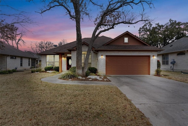 view of front of home featuring a garage and a yard