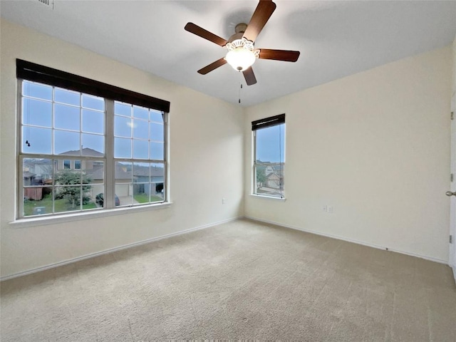 carpeted spare room featuring ceiling fan