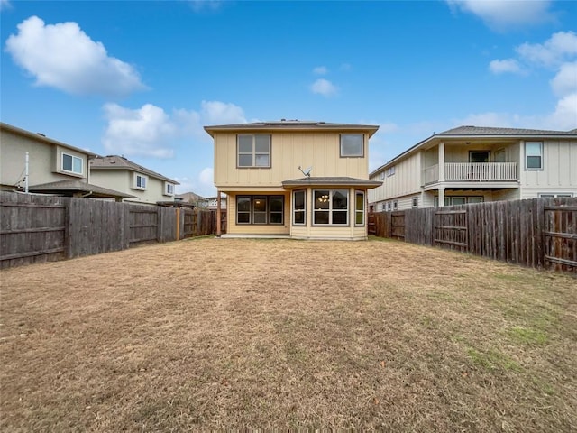 rear view of house featuring a yard and a patio