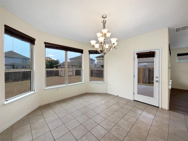 unfurnished dining area with an inviting chandelier and light tile patterned flooring