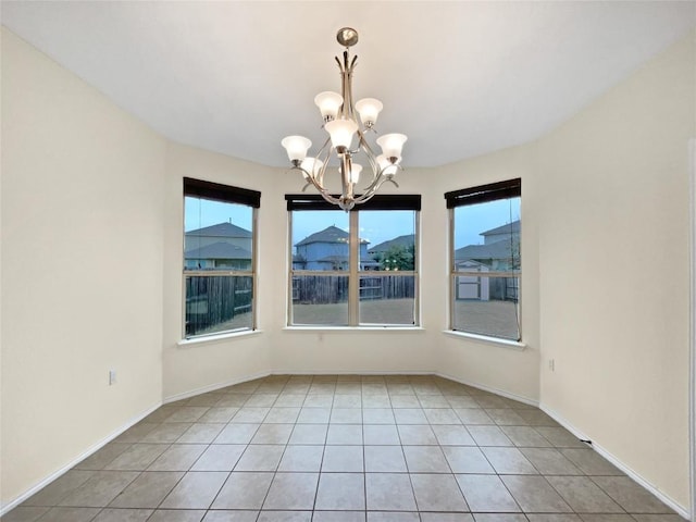 unfurnished dining area featuring an inviting chandelier, light tile patterned floors, and a wealth of natural light