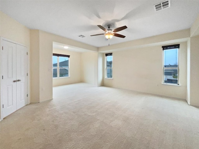 unfurnished bedroom featuring light colored carpet and ceiling fan