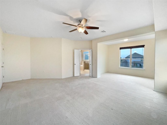 spare room featuring light colored carpet and ceiling fan