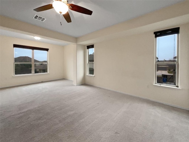 carpeted spare room featuring a mountain view and ceiling fan