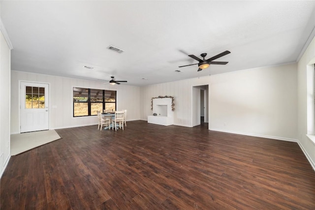 unfurnished living room with ceiling fan, ornamental molding, and dark hardwood / wood-style floors