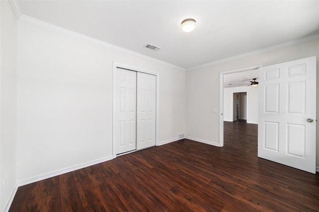 unfurnished bedroom with crown molding, dark hardwood / wood-style floors, and a closet