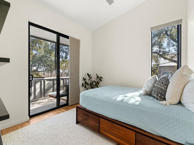 bedroom with access to exterior, multiple windows, and light hardwood / wood-style flooring