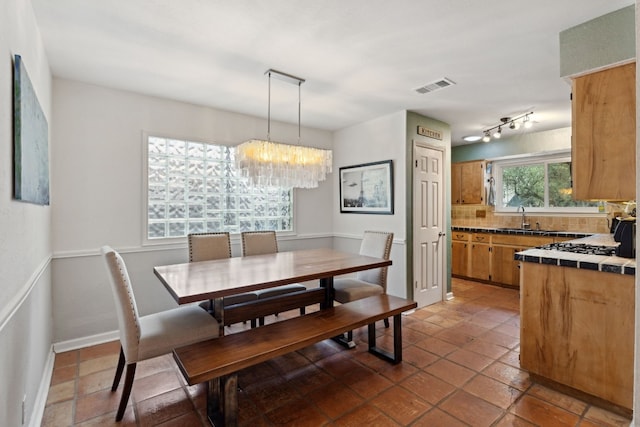 dining space with a chandelier and sink