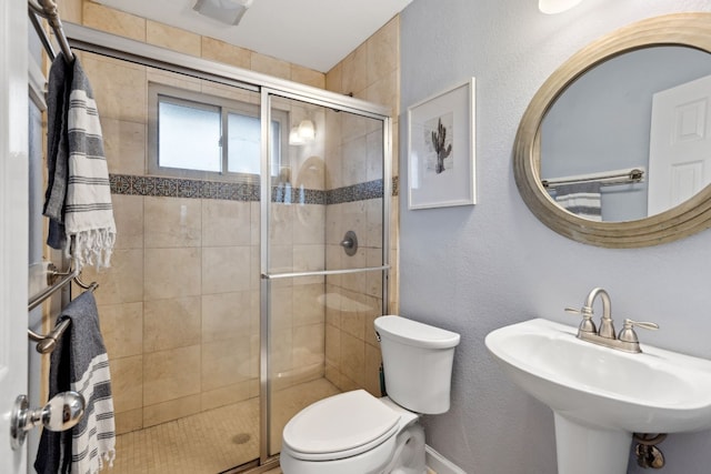 bathroom with toilet, an enclosed shower, and sink