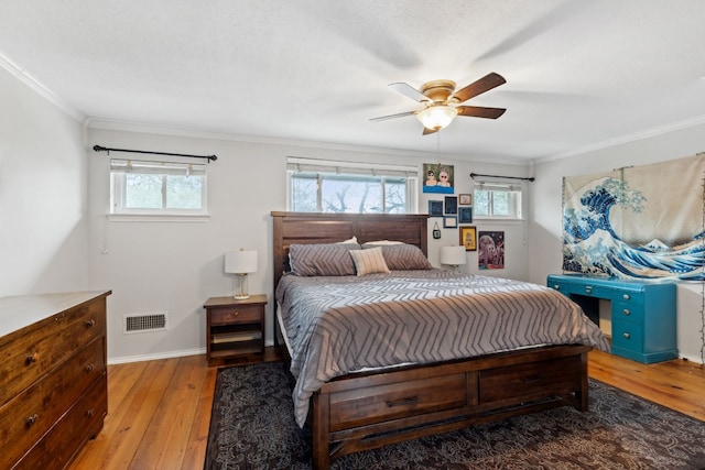 bedroom featuring hardwood / wood-style flooring, ornamental molding, and ceiling fan