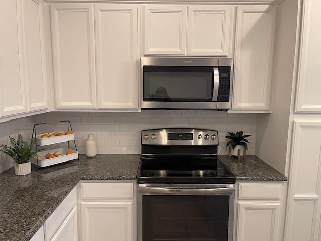 kitchen with dark stone countertops, appliances with stainless steel finishes, and white cabinets