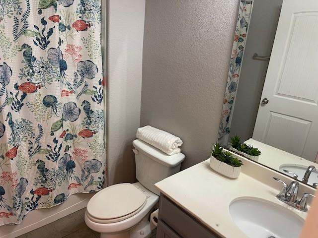 bathroom featuring tile patterned flooring, vanity, and toilet