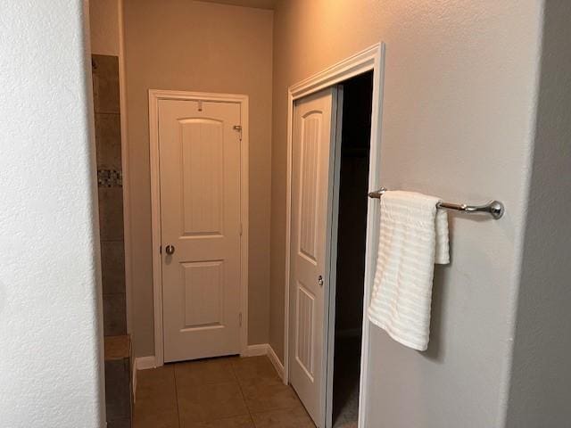 hallway featuring dark tile patterned floors