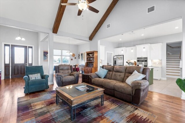 1430 Antioch Rd, Paige, TX 78659 - living area with a chandelier, stairs, ceiling fan, beamed ceiling, and high vaulted ceiling