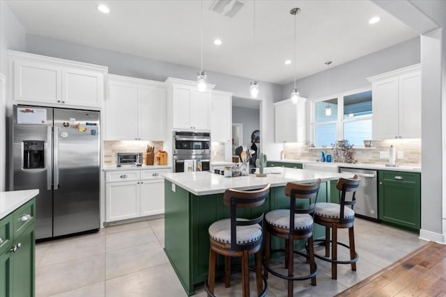 1430 Antioch Rd, Paige, TX 78659 - kitchen featuring stainless steel appliances, green cabinetry, light countertops, backsplash, and recessed lighting