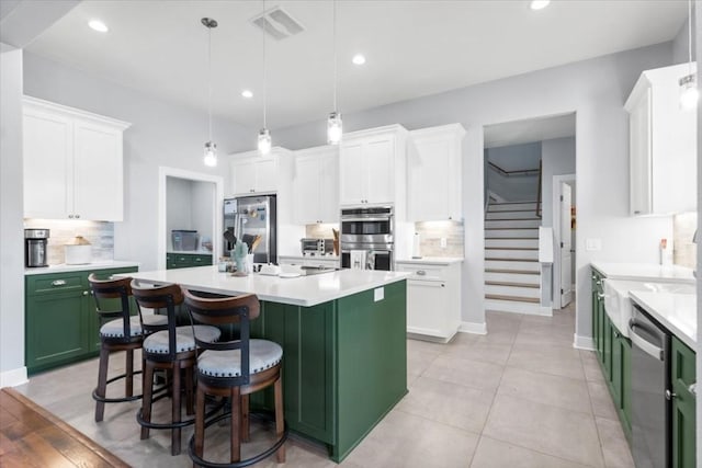 1430 Antioch Rd, Paige, TX 78659 - kitchen with stainless steel appliances, green cabinetry, decorative backsplash, light countertops, and white cabinetry