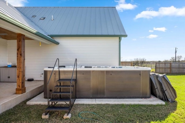 view of patio / terrace featuring fence and a hot tub