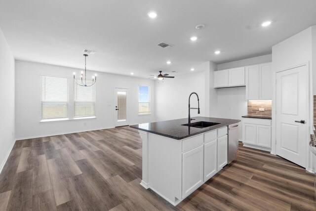 4829 Mozzafiato Ln, Round Rock, TX 78665 - kitchen with stainless steel dishwasher, recessed lighting, dark wood finished floors, decorative backsplash, and white cabinetry